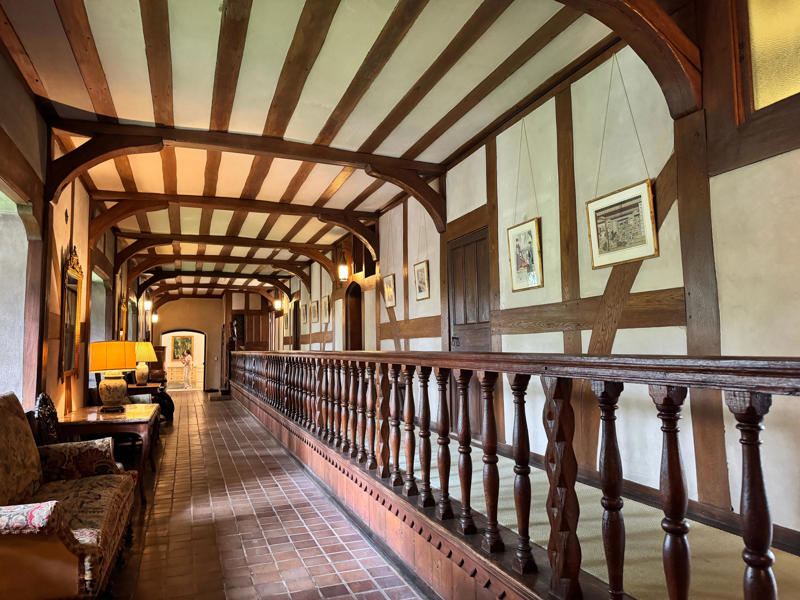 There are personalized touches all over the house's limestone exterior., It took three years to complete Coe Hall., One of the first rooms you can view is Coe's den., It's covered in dark wood, giving a masculine atmosphere., The art in the living room is original to the home., It's certainly not a bad place to spend your weekends., The craftsmanship throughout the house was impossible to miss., There was another portrait of Coe hanging in the corner., The main staircase felt straight out of a castle., And no, that's not wallpaper. This design was hand-painted onto the wall., The windows gave her a view of the gardens she painstakingly designed., This is her bathroom. Once again, it's very French., Now it was time to check out the much-revered grounds., Right off the bat, this fountain caught my eye., Can't you just hear someone saying, "Once upon a time…"?, Rogers entertained her friends in the Tea House on nice days., It looks like the inside of a Tiffany's box., Walking through it felt like walking through a storybook., One corner of the building was anchored by this giant palm tree., It has the largest collection of camellias under glass in the northeast., However, camellia season is in January, so we missed it.