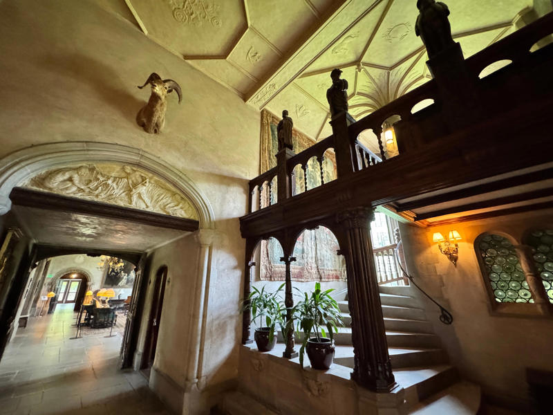 There are personalized touches all over the house's limestone exterior., It took three years to complete Coe Hall., One of the first rooms you can view is Coe's den., It's covered in dark wood, giving a masculine atmosphere., The art in the living room is original to the home., It's certainly not a bad place to spend your weekends., The craftsmanship throughout the house was impossible to miss., There was another portrait of Coe hanging in the corner., The main staircase felt straight out of a castle., And no, that's not wallpaper. This design was hand-painted onto the wall., The windows gave her a view of the gardens she painstakingly designed., This is her bathroom. Once again, it's very French., Now it was time to check out the much-revered grounds., Right off the bat, this fountain caught my eye., Can't you just hear someone saying, "Once upon a time…"?, Rogers entertained her friends in the Tea House on nice days., It looks like the inside of a Tiffany's box., Walking through it felt like walking through a storybook., One corner of the building was anchored by this giant palm tree., It has the largest collection of camellias under glass in the northeast., However, camellia season is in January, so we missed it.