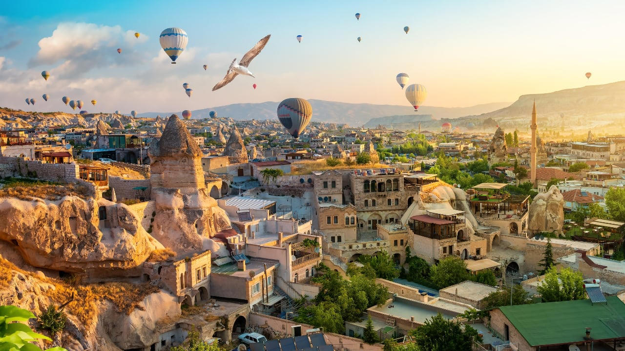 8. Goreme, Turkey Caves carved by wind and wonder—Goreme belongs to the Earth, not to man. Fairy chimneys pierce the sky, and hot-air balloons rise like thoughts at dawn. It is a village of both ground and sky. (Image: Canva) 1. Hallstatt, Austria Balanced between lake and limestone, Hallstatt reads like a forgotten chapter from an alpine fable. Its salt-stained history, mirrored waters, and slate-roofed homes draw quiet reverence, not crowds. In winter, it feels paused; in summer, painted. (Image: Canva), 2. Shirakawa-go, Japan Cradled by mountains and wrapped in thatch, Shirakawa-go holds firm to tradition. Its steep-roofed farmhouses, designed to endure snow and time, glow amber at dusk. The seasons arrive like guests—welcomed, noticed, remembered. (Image: Canva), 3. Colmar, France Colmar does not ask for attention—it commands it. With its riot of half-timbered homes, canal reflections, and Alsatian flourishes, it walks the line between theatre and truth. Even its shadows are deliberate. (Image: Canva), 4. Bibury, England Set beside the Coln and stitched into the hills, Bibury whispers of England before speed. Honey-coloured cottages in tight rows, trout streams that glisten without reason, and hedgerows that seem older than maps. (Image: Canva), 5. Giethoorn, Netherlands There are no cars in Giethoorn. Only boats, bridges, and hushed conversations. It is a village that floats, slowly, in its own rhythm. The canals speak softly; the thatched roofs never hurry. (Image: Canva), 6. Reine, Norway Beyond the Arctic Circle lies Reine—a scattering of crimson cabins that appear borrowed from a painting. Mountains rise like frozen waves behind them, and the sea never stops watching. Reine is remote, but never empty. (Image: Canva), 7. Eze, France High above the Riviera, where the cliffs fall into blue, sits Eze—a village of stone and shadow. Its alleys twist upward as if climbing toward memory. Time lingers here, in the scent of thyme and sea. (Image: Canva), 8. Goreme, Turkey Caves carved by wind and wonder—Goreme belongs to the Earth, not to man. Fairy chimneys pierce the sky, and hot-air balloons rise like thoughts at dawn. It is a village of both ground and sky. (Image: Canva), 9. Dinant, Belgium Hemmed in by cliff and river, Dinant feels composed rather than built. Saxophones hang from bridges, limestone watches from above, and the Meuse flows through it like a quiet refrain. Gothic never looked so lyrical. (Image: Canva), 10. Leavenworth, Washington, USA This village is not a replica—it’s a reinvention. Bavarian beams beneath American skies, brats beside apple pie. Surrounded by pine, performance, and peaks, Leavenworth is both celebration and curiosity, wrapped in wood and wonder. (Image: Canva)