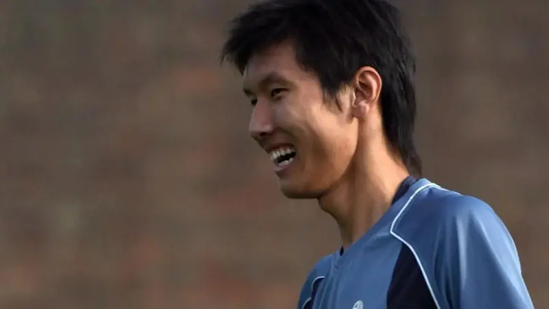間違いなく、この中国人は史上最も背の高いサッカー選手一人だ。, 2019年に引退した同選手の身長は205センチ。, ヘディングが得意なスターストライカーだった。, その長身から、チームメイトから良くハイボールを受けていた。, もちろん、ヘディングで競り勝つのは難しい。, テクニックは劣ったが、長身のおかげで活躍。, この身長では機敏に動くことはできなかった。, 2006年にボルトンのセレクションを受けたが、残念ながら落選。, 2008年武漢でデビュー。, キャリア通算86試合に出場し、12ゴールをマークした。, 残念ながら、国際的な試合でインパクトを与えることはできなかった。
