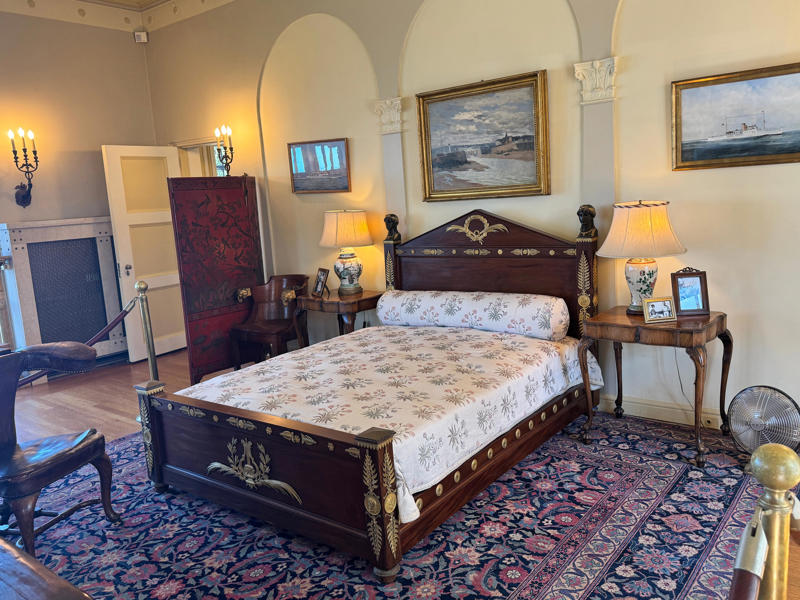 His bed, seen here, was a to-scale replica of the bed of Napoleon Bonaparte. Inside the grounds are hiking trails, gardens, and a gift shop., Before I toured the home, I visited the museum grounds., But the landscaping was still immaculate., Then it was time to head over to Eagle's Nest., One side of the mansion is a natural history museum., The first room I saw was the dining room., The ceiling is constructed from Florida cedar, or Southern Red cedar., This is her changing room and bathroom., The house was set on a hill, so the yard was multi-level., First, I walked to the right., There was a large reflecting pool., But the main attraction was, once again, the view., To my surprise, it was a filled-in saltwater pool., They'd even left the ladder in., There were also changing rooms.