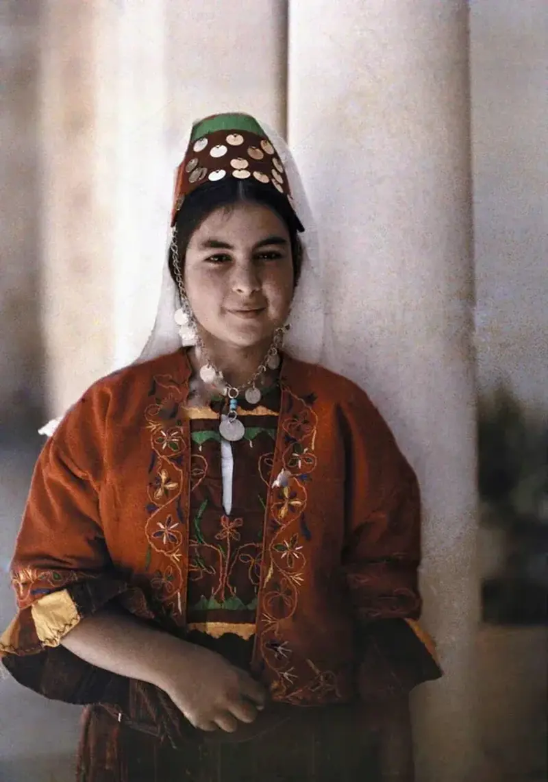 30. 35. "Lili'uokalani, the overthrown final monarch of the Hawaiian Kingdom, sitting on the porch of her private residence with her dog Poni, 1917", 33. "Jewish Children with their Teacher in Samarkand. Early color photograph from Russia, created by Sergei Mikhailovich Prokudin-Gorskii as part of his work to document the Russian Empire from 1909 to 1915", 31. "Aboriginal boy and puppy. Australia, 1914. Photo by Frank Hurley", 30. "An Arab Christian Girl from Bethlehem. 1923", 29. "Watusi Man in Ruanda (now Rwanda) in the 1920s", 27. "An Abyssinian (Ethiopian) warrior, carrying a rifle and shield and wearing a lion’s mane headdress, at the coronation ceremonies of Emperor Haileselassie, 1930", 25. "Peruvian woman with her baby in the Andes, 1930s-1940s", 24. "A Uighur dancer performing to music. Xinjiang, 1943. Photo taken by William Vandivert", 23. "Radna Ayusheev, an ethnic Bashkir apart of the 63rd Soviet Naval Infantry Brigade, 1944", 22. "Pakistani swimmers Sultan Karim Ali (L) and Anwar Aziz Chaudhry (R) at the Empire Pool in Wembley, London, during the 1948 Summer Olympics (United Kingdom 1948)", 20. "A Japanese Geisha wearing a kimono and sitting with her Samisen, a traditional string instrument - 1950", 18. "Korean children at the Malli-dong neighbourhood, in Seoul, South Korea - 1959", 17. "Dancing in Ghana — 1961/2", 16. "A Kurdish peshmerga with his family in Iraqi Kurdistan. 1965", 15. "Children from Gorkha, Nepal during 1970", 14. "Nils Johan Mienna, a boy belonging to the Sami people, poses for the camera in his traditional costume. Norway, 1977, By Erik Borg for the National Geographic", 12. "Khmer Rouge child soldiers with M16 rifles, Galaw, Cambodia (1979)", 11. "Afghan Girl, 1984", 10. "East-Timorese women photographed during the Indonesian occupation of East-Timor, 1984", 9. "San woman in Namibia listening to some tunes (1984)", 8. "Turkmen boys wear traditional traditional Telpek hats, (1980s), Turkmen SSR", 5. "Cakchiquel people of Patzutzun, Guatemala, 1993. Photographed by John Isaac", 4. "A Chechen veteran fighting as a volunteer during the First Chechen War, 1994"