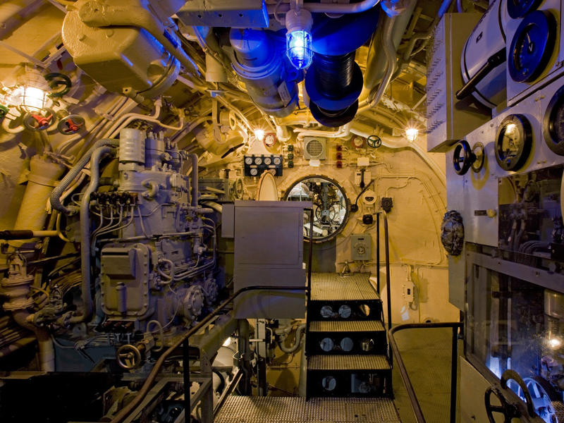 Our last stop on the tour was the electric motor room, with a pit stop to see the sea strainer valve. Bullet holes can be seen all over the conning tower., The first stop on my tour was the petty officer's quarters., When the U-505 was on patrol, it carried 12 tons of food., The crew had to navigate various challenges while underwater, including high temperatures., All calculations before firing a torpedo were done with pen and paper., The US Navy captured the U-505 on June 4, 1944., To prevent the U-505's capture, the Germans tried one last trick., On September 2, 1954, the submarine was hauled across Lake Shore Drive in Chicago., At first, the submarine was displayed outside the museum.