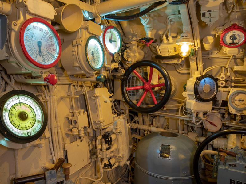 The control room had a dizzying number of switches, wires, and valves, which were used to control the ship's direction. Bullet holes can be seen all over the conning tower., The first stop on my tour was the petty officer's quarters., When the U-505 was on patrol, it carried 12 tons of food., The crew had to navigate various challenges while underwater, including high temperatures., All calculations before firing a torpedo were done with pen and paper., The US Navy captured the U-505 on June 4, 1944., To prevent the U-505's capture, the Germans tried one last trick., On September 2, 1954, the submarine was hauled across Lake Shore Drive in Chicago., At first, the submarine was displayed outside the museum.