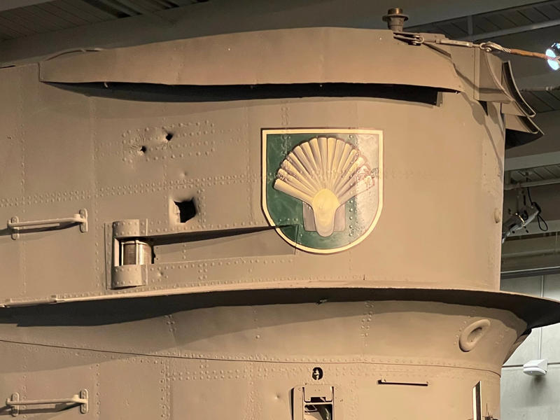 German crewmembers honored their captains by adopting and painting unofficial emblems on the conning tower. Bullet holes can be seen all over the conning tower., The first stop on my tour was the petty officer's quarters., When the U-505 was on patrol, it carried 12 tons of food., The crew had to navigate various challenges while underwater, including high temperatures., All calculations before firing a torpedo were done with pen and paper., The US Navy captured the U-505 on June 4, 1944., To prevent the U-505's capture, the Germans tried one last trick., On September 2, 1954, the submarine was hauled across Lake Shore Drive in Chicago., At first, the submarine was displayed outside the museum.