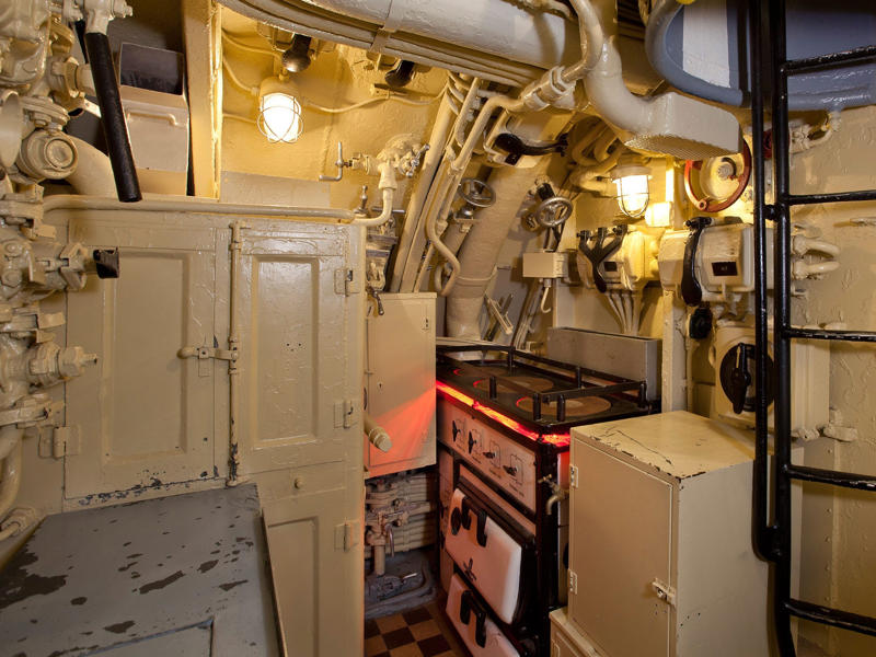 Next, I walked past a narrow hallway and saw the galley sandwiched between other sleeping quarters. Bullet holes can be seen all over the conning tower., The first stop on my tour was the petty officer's quarters., When the U-505 was on patrol, it carried 12 tons of food., The crew had to navigate various challenges while underwater, including high temperatures., All calculations before firing a torpedo were done with pen and paper., The US Navy captured the U-505 on June 4, 1944., To prevent the U-505's capture, the Germans tried one last trick., On September 2, 1954, the submarine was hauled across Lake Shore Drive in Chicago., At first, the submarine was displayed outside the museum.