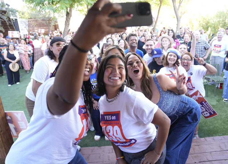 Deja Foxx and Chrissy Teigen take a selfie Deja Foxx on stage at Global Citizen NOW summit, Deja Foxx in Press Room at Jingle Ball 2021, Deja Foxx speaking at Moonpie event in Phoenix, Doug Emhoff greeted by local officials in Arizona, Adelita S. Grijalva at Lukeville Port conference, Deja Foxx and Chrissy Teigen take a selfie, Jeff Flake and Loretta Lynch at Purdue University