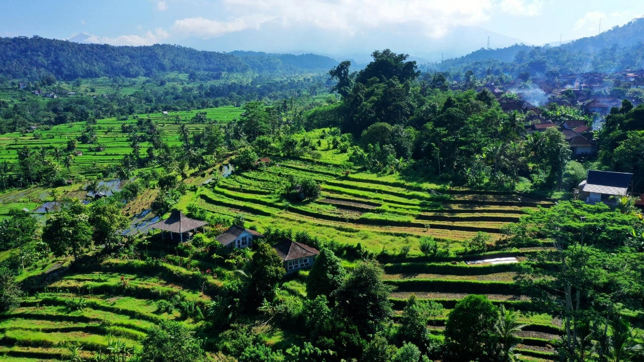 1. Sidemen Valley: The Soul of Rural Bali Located in East Bali, Sidemen is a lush valley that feels like a time capsule. The region is framed by Mt. Agung, Bali’s sacred volcano, and layered with stunning rice terraces, bamboo forests, and sleepy villages. Hike through the fields, visit traditional weaving centers, or simply relax in a bamboo hut overlooking a river. It’s a favorite among yogis, writers, and slow travelers looking to escape the buzz of Ubud. Why go: Serene landscapes, fewer tourists, great base for cultural immersion and eco-friendly stays. (Image: Canva) 1. Sidemen Valley: The Soul of Rural Bali Located in East Bali, Sidemen is a lush valley that feels like a time capsule. The region is framed by Mt. Agung, Bali’s sacred volcano, and layered with stunning rice terraces, bamboo forests, and sleepy villages. Hike through the fields, visit traditional weaving centers, or simply relax in a bamboo hut overlooking a river. It’s a favorite among yogis, writers, and slow travelers looking to escape the buzz of Ubud. Why go: Serene landscapes, fewer tourists, great base for cultural immersion and eco-friendly stays. (Image: Canva), 2. Nyang Nyang Beach: Bali’s Untamed Coastline One of the last untouched beaches in South Bali, Nyang Nyang demands effort—around 500 steps down a cliff—but rewards you with solitude, turquoise waves, and dramatic limestone backdrops. You won’t find sunbeds or bars here—just driftwood, wildflowers, and your own patch of sand. Tip: Go early in the morning to avoid the heat and enjoy the beach in silence. (Image: Canva), 3. Sangeh Monkey Forest: Tranquility Amidst Sacred Trees Tucked away in Badung Regency, Sangeh Monkey Forest is older and quieter than its more famous cousin in Ubud. The forest is home to towering nutmeg trees, Balinese temples, and a well-behaved tribe of macaques known for their less aggressive nature. It’s perfect for a quiet cultural detour. Insider fact: Locals believe the trees in the forest are sacred and spiritually protected. (Image: Canva), 4. Amed: A Diver’s Hideaway with a Laid-Back Vibe Amed’s coastline is worlds apart from Seminyak’s glitz. With its volcanic black-sand beaches, traditional jukung boats bobbing in the water, and easy access to coral reefs and WWII shipwrecks, it’s a paradise for snorkelers and divers. The pace is slow, the people warm, and the sunsets unforgettable. Don’t miss: Sunrise views of Mount Agung and a day trip to the Japanese shipwreck in Lipah Beach. (Image: Canva), 5. Munduk: Bali’s Misty Mountain Escape Set high in Bali’s northern highlands, Munduk is a tranquil village surrounded by coffee plantations, waterfalls, and dense forests. Cooler temperatures and misty mornings create a refreshing contrast to the island’s coast, inviting visitors to explore hiking trails and traditional villages far from the tourist bustle. Why it’s special: A peaceful retreat for nature lovers and trekkers seeking unspoiled landscapes and authentic local culture. (Image: Canva), 6. Penglipuran Village: Tradition Preserved in Harmony This Balinese Hindu village near Bangli is renowned for its commitment to preserving traditional architecture and customs. The village layout is based on the Tri Mandala concept—spatial zoning rooted in Balinese cosmology. It’s meticulously clean, with manicured gardens and bamboo forests at its edge. Why visit: Witness authentic Balinese culture and community-driven sustainability in action. (Image: Canva), 7. Banyu Wana Amertha Waterfall: A Hidden Natural Wonder Tucked away in the lush hills of Buleleng, this collection of waterfalls is lesser-known but absolutely spectacular. Multiple falls cascade through the jungle, offering secluded swimming spots and stunning photo opportunities. A short trek through flower farms and coffee plantations adds charm to the journey. Pro tip: Wear water shoes and bring a picnic for a truly immersive nature escape. (Image: Canva), 8. Menjangan Island: Bali’s Best Snorkeling Without the Crowds Situated in West Bali National Park, Menjangan Island is part of a protected marine reserve. The water clarity is exceptional, with vibrant coral walls, reef fish, and occasional sightings of reef sharks or turtles. On land, the island is home to wild deer that roam freely. Good to know: Access is by boat from Labuan Lalang; guided snorkel or dive trips can be arranged locally. (Image: Canva), 9. Pura Beji Sangsit: A Hidden Temple of Intricate Carvings Located in the village of Sangsit in North Bali, Pura Beji is a serene temple famed for its elaborate stone carvings and unique architectural style. Unlike the bustling temples near Ubud, it offers a peaceful atmosphere where visitors can appreciate Bali’s rich artistic heritage in quiet contemplation. What makes it unique: The temple’s detailed decorations and tranquil setting provide a glimpse into traditional Balinese craftsmanship away from tourist crowds. (Image: Canva)