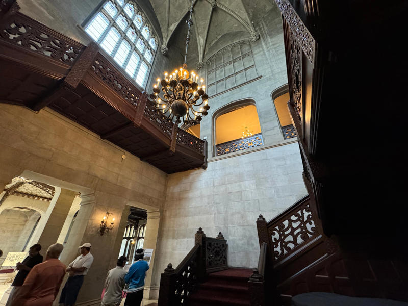Today, you can tour Hempstead House. This entryway, with its original 60-foot chandelier, is one of the focal points of the home. It also features the largest fireplace in the home., The billiards room also has a luxurious window seat., Directly next to the breakfast room was another wood-paneled study., It has yet another perfect window seat., It's also one of the only rooms with a private bathroom., We stopped at one more guest room, which was more modest., As the tour concluded, we were able to explore the gardens outside.