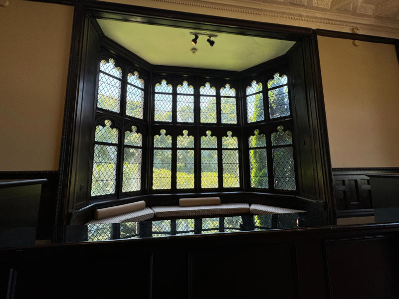 The billiards room also has a luxurious window seat. It also features the largest fireplace in the home., The billiards room also has a luxurious window seat., Directly next to the breakfast room was another wood-paneled study., It has yet another perfect window seat., It's also one of the only rooms with a private bathroom., We stopped at one more guest room, which was more modest., As the tour concluded, we were able to explore the gardens outside.