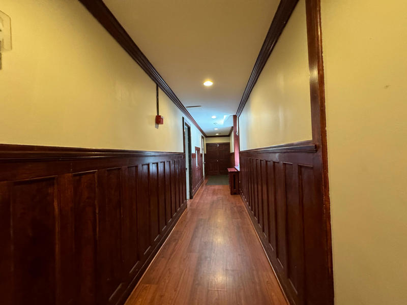 This is the separate servants' hallway. I learned that at its peak, Hempstead House had 16 servants living in the home, plus more in Castle Gould. It also features the largest fireplace in the home., The billiards room also has a luxurious window seat., Directly next to the breakfast room was another wood-paneled study., It has yet another perfect window seat., It's also one of the only rooms with a private bathroom., We stopped at one more guest room, which was more modest., As the tour concluded, we were able to explore the gardens outside.