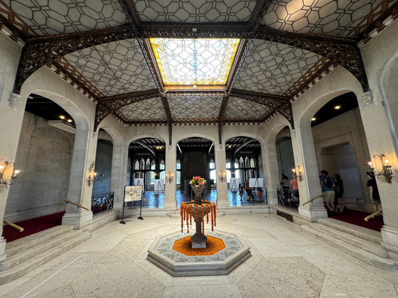 Immediately to the left is what was once known as the Palm Court. The ceiling used to be entirely glass, giving it a greenhouse feel. The metalwork is all original to the Guggenheims' time. It also features the largest fireplace in the home., The billiards room also has a luxurious window seat., Directly next to the breakfast room was another wood-paneled study., It has yet another perfect window seat., It's also one of the only rooms with a private bathroom., We stopped at one more guest room, which was more modest., As the tour concluded, we were able to explore the gardens outside.
