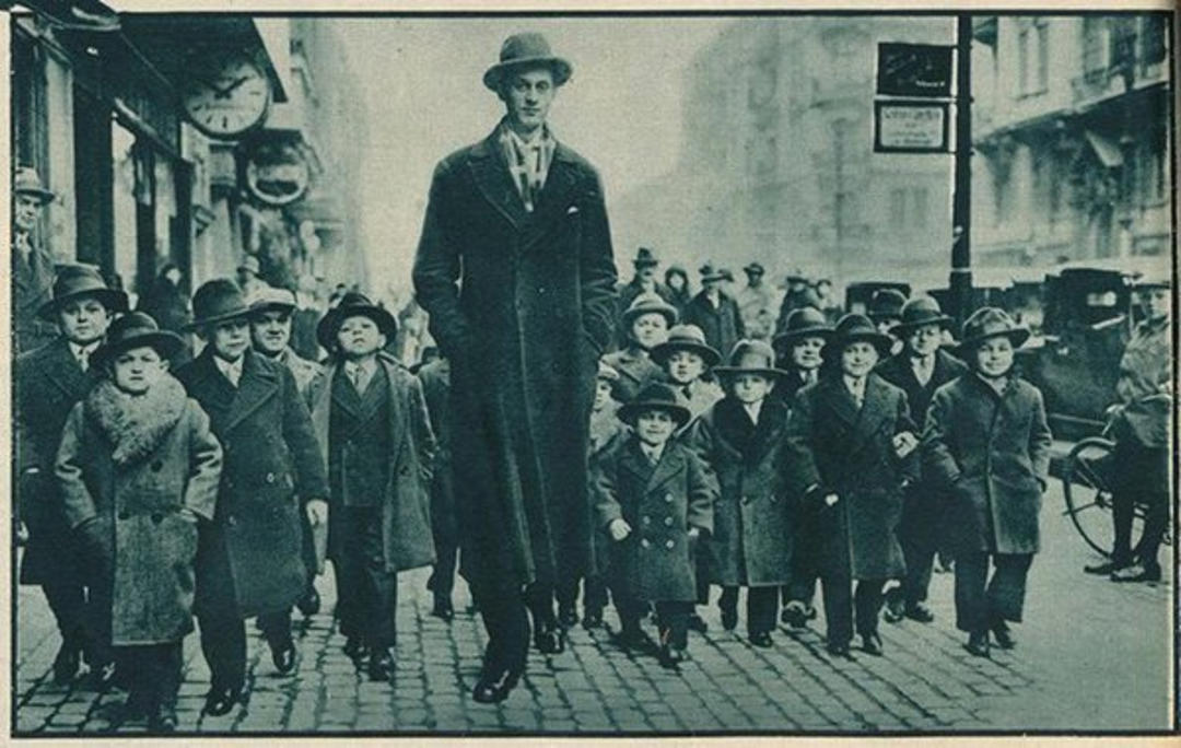 13. Jacob Rheuben Ehrlich (8 ft 6 in) walking the Chicago streets with kids, 1932 1. A World War Veteran, 1932, 2. Jean Bugatti standing next to his Bugatti Royale, one of the seven he built, 1932, 3. This milkmaid is trying to get the pig off the road, Norway, 1932, 4. Joan Crawford, 1932, 5. Just a young girl and her dog, 1932, 6. Taking a break after their tennis match, Washington DC, 1932, 7. Charles Ebbets shooting his famous photo, Lunch atop a Skyscraper, 1932, 8. Rocking the fur coats and a Cadillac in Harlem, 1932, 9. Painting the Eiffel Tower in 1932, 10. Sitting in peace in NYC, 1932, 11. Driving a dynasphere, 1932, 12. Harpo Marx and Amelia Earhart on the set of Horse Feathers, 1932, 13. Jacob Rheuben Ehrlich (8 ft 6 in) walking the Chicago streets with kids, 1932, 14. Sitting on a truck, playing her guitar in Amarillo, Texas, 1932, 15. A family portrait in Poland, 1932, 16. A colorized portrait of Amelia Earhart, 1932, 17. A woman bringing her pet cat to have a cup of tea, 18. Charles C. Ebbets snapping photos on a skyscraper, 1932, 19. Young Love, 1932, 20. Stan Laurel and Oliver Hardy taking a break from filming, 1932, 21. Fighting their way through the snow, 1932, 22. Taking an extremely unsafe nap, 1932, 23. Street fashion in Japan, 1932, 24. This is what packing for a camping trip looked like in 1932