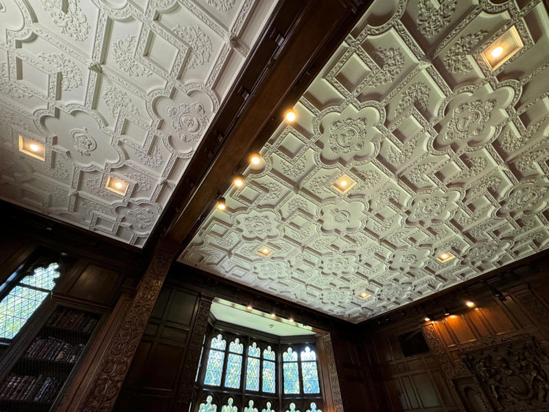 The ornate ceiling in this room is original, with busts of Shakespeare and other scholars engraved into the plaster. It also features the largest fireplace in the home., The billiards room also has a luxurious window seat., Directly next to the breakfast room was another wood-paneled study., It has yet another perfect window seat., It's also one of the only rooms with a private bathroom., We stopped at one more guest room, which was more modest., As the tour concluded, we were able to explore the gardens outside.