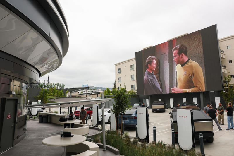 The Tesla Diner is in West Hollywood, California., Wallpaper inside the restaurant broadcasts Tesla's mission to diners., The diner's website says it has 80 Supercharger stalls., Besides the food and charging access, it's also part drive-in movie theater.