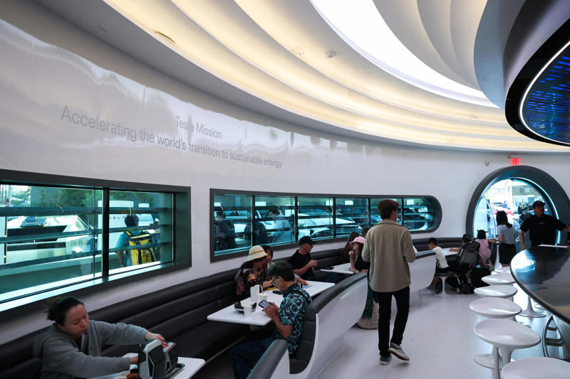 The Tesla Diner is in West Hollywood, California., Wallpaper inside the restaurant broadcasts Tesla's mission to diners., The diner's website says it has 80 Supercharger stalls., Besides the food and charging access, it's also part drive-in movie theater.