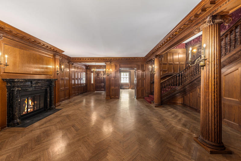 The entry gallery on the first floor features wood paneling throughout. The five-story townhouse is located across from the Museum of Modern Art., The entry gallery on the first floor features wood paneling throughout., Neo-Georgian architectural touches include columns and decorative molding known as cornices., Two staircases lead to the upper floors., Rooms on the upper floors feature floor-to-ceiling windows and Juliet balconies., The dining room is shaped like an octagon.