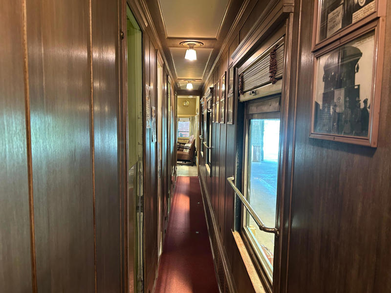 A narrow hallway led from the staterooms to the observation deck. To carry the president, the unique armored car had enhanced security features., In the kitchen, an onboard chef had access to ovens and refrigerators., The car housed two staff members: a chef and a porter., The car included two guest bedrooms along with a presidential suite., The presidential suite included the president's sleeping area., The first lady's room was located parallel to the president's., A narrow hallway led from the staterooms to the observation deck., The observation lounge featured some of the presidential car's original furniture., During the refurbishment, a submarine escape hatch was added to the car.