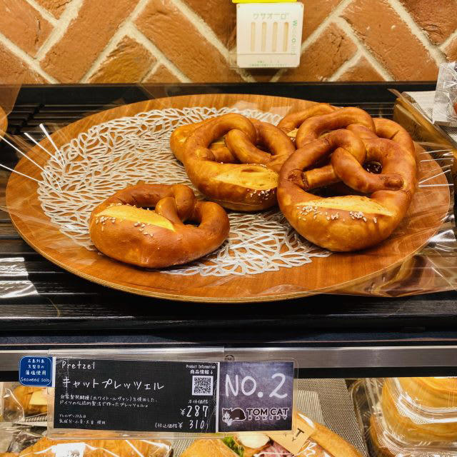 パンとネコに癒される♪「TOM CAT BAKERY 大阪店」でいただく幸せモーニング, 【人気No.1】Mr.シナモン, 【人気No.2】キャットプレッチェル, 実食レポ！オススメパンはコレ, キャットプレッチェル, フォカッチャ エッグシュリンプ＆アボカド, レイヤークロワッサン, アイスカフェラテ, 隠れネコ足跡を探せ！ネコデザイン溢れる店内