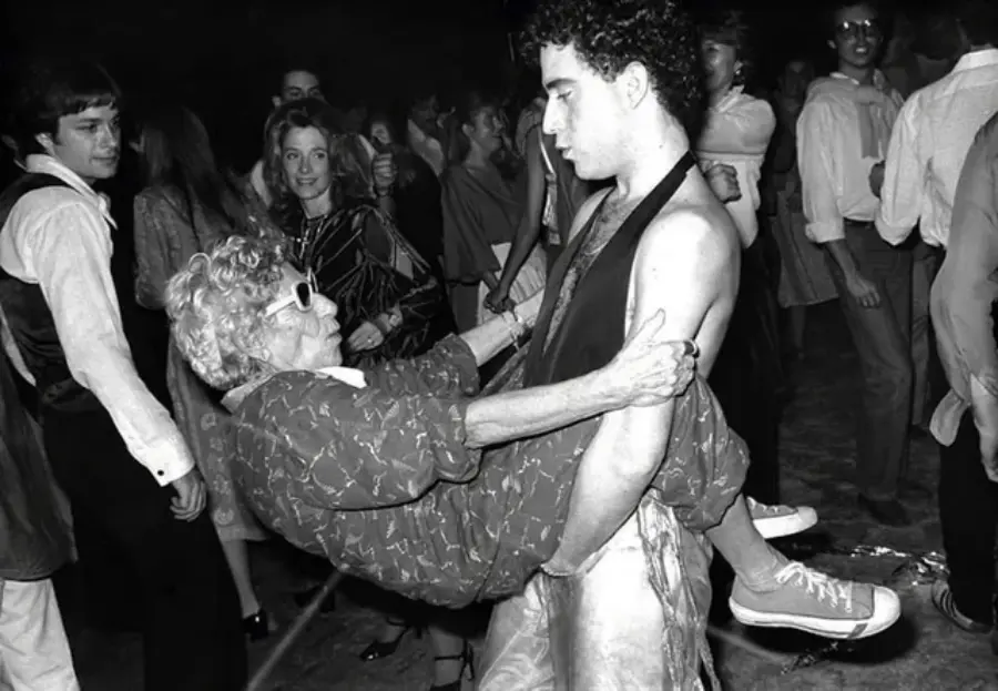 3. Disco Sally, a 78-Year-Old Studio 54 Regular, Becomes a Symbol of the Era in 1978 1. Waiting In Line to See Star Wars, 1977, 2. January 19th 1977, The One and Only Day it Snowed in Miami, 3. Disco Sally, a 78-Year-Old Studio 54 Regular, Becomes a Symbol of the Era in 1978, 4. A Businessman Lights a Cigarette Inside a New York City Phone Booth in 1980, 5. Two Women Sit Casually on a Fire Escape in Harlem, NYC, in 1978, 6. Harrison Ford Appears as Colonel G. Lucas in Apocalypse Now, 1979, 7. In 1978, a Toddler Poses Next to the Family's New Color TV Like It's a Family Member, 8. Salesmen Sit on the Hoods of New Cars Waiting for Buyers at a California Dealership in 1979, 9. Kids Jump From a Fire Escape Onto Mattresses in NYC's Lower East Side, 1979, 10. Comic-Con San Diego in 1980 Captures the Wild Beginnings of Pop Culture Fandom, 11. The World's Largest Disco Draws Crowds to Buffalo in 1978, 12. Young Roller Skater in Red Moves Through Midtown Manhattan, 1979, 13. In 1978, Disco Dancing Lessons Spread to Suburbs Like Beaverton, Oregon, 14. An Apple II Computer and a Young Steve Jobs Revolutionize Tech in 1977, 15. A Woman Leans in to Kiss a Windsor Guard in a Whimsical Moment, 1980, 16. Two Guys Play Atari in Their Living Room in 1978, Defining Home Entertainment, 17. National Space Invaders Championship in 1980 Showcases a New Era of Gamers, 18. A Local News Crew in Texas Interviews Parents After Taking Kids to See Alien, 1979, 19. Young Woman in a "Consenting Adult" Shirt Enjoys the Rolling Stones in 1978, 20. In 1979, Reflections on the Dance Floor Captured the Disco Craze From Above, 21. A Canadian Gas Station Refuses to Fuel Soviet Ladas to Protest the Invasion of Afghanistan, 1980, 22. Subway Riders Carry Lawn Chairs for a Beach Day in NYC, Summer 1978, 23. High School Seniors Pose Before Heading on a Ski Trip in 1980, 24. Young Girl Embraces Teddy Boy Fashion and Rock 'n' Roll Dancing, 1979, 25. In 1980, Bronx Teens Turn the Streets Into a Stage With BMX Tricks, 26. Olivia Newton-John and John Travolta Redefine Teen Style on the Set of Grease, 1978, 27. KISS Fans in Buffalo, NY, Fully Embrace Glam Rock Culture, 1978, 28. New UK Prime Minister Margaret Thatcher Celebrates Her Election Victory, 1979, 29. The Sony Walkman Hits the Market With a Bold Ad Declaring "There's a Revolution in the Streets", 1980, 30. A Young Man Spins the Top Hits of 1978 on AM Radio Studio, 31. Four New Jersey Teens Check Under the Hood of a Car With a Backwards Design, 1979, 32. Elvis Presley's Final Performance in 1977 Leaves Fans With an Iconic Farewell, 33. Protesters Flood the Capitol in March 1980 to Oppose Military Draft Registration, 34. Staten Island Families Resort to Kerosene Lamps During the 1977 Blackout