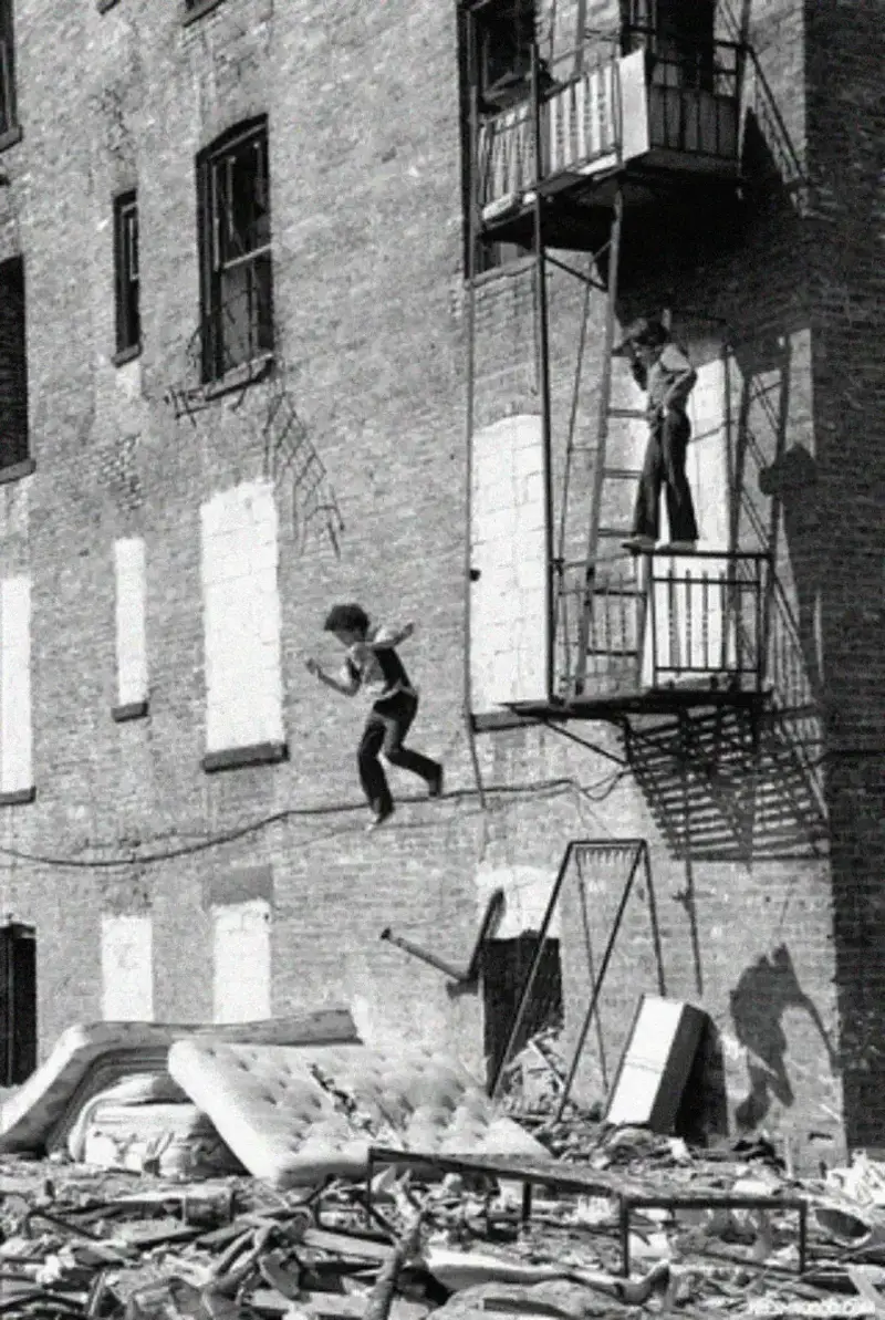 9. Kids Jump From a Fire Escape Onto Mattresses in NYC's Lower East Side, 1979 1. Waiting In Line to See Star Wars, 1977, 2. January 19th 1977, The One and Only Day it Snowed in Miami, 3. Disco Sally, a 78-Year-Old Studio 54 Regular, Becomes a Symbol of the Era in 1978, 4. A Businessman Lights a Cigarette Inside a New York City Phone Booth in 1980, 5. Two Women Sit Casually on a Fire Escape in Harlem, NYC, in 1978, 6. Harrison Ford Appears as Colonel G. Lucas in Apocalypse Now, 1979, 7. In 1978, a Toddler Poses Next to the Family's New Color TV Like It's a Family Member, 8. Salesmen Sit on the Hoods of New Cars Waiting for Buyers at a California Dealership in 1979, 9. Kids Jump From a Fire Escape Onto Mattresses in NYC's Lower East Side, 1979, 10. Comic-Con San Diego in 1980 Captures the Wild Beginnings of Pop Culture Fandom, 11. The World's Largest Disco Draws Crowds to Buffalo in 1978, 12. Young Roller Skater in Red Moves Through Midtown Manhattan, 1979, 13. In 1978, Disco Dancing Lessons Spread to Suburbs Like Beaverton, Oregon, 14. An Apple II Computer and a Young Steve Jobs Revolutionize Tech in 1977, 15. A Woman Leans in to Kiss a Windsor Guard in a Whimsical Moment, 1980, 16. Two Guys Play Atari in Their Living Room in 1978, Defining Home Entertainment, 17. National Space Invaders Championship in 1980 Showcases a New Era of Gamers, 18. A Local News Crew in Texas Interviews Parents After Taking Kids to See Alien, 1979, 19. Young Woman in a "Consenting Adult" Shirt Enjoys the Rolling Stones in 1978, 20. In 1979, Reflections on the Dance Floor Captured the Disco Craze From Above, 21. A Canadian Gas Station Refuses to Fuel Soviet Ladas to Protest the Invasion of Afghanistan, 1980, 22. Subway Riders Carry Lawn Chairs for a Beach Day in NYC, Summer 1978, 23. High School Seniors Pose Before Heading on a Ski Trip in 1980, 24. Young Girl Embraces Teddy Boy Fashion and Rock 'n' Roll Dancing, 1979, 25. In 1980, Bronx Teens Turn the Streets Into a Stage With BMX Tricks, 26. Olivia Newton-John and John Travolta Redefine Teen Style on the Set of Grease, 1978, 27. KISS Fans in Buffalo, NY, Fully Embrace Glam Rock Culture, 1978, 28. New UK Prime Minister Margaret Thatcher Celebrates Her Election Victory, 1979, 29. The Sony Walkman Hits the Market With a Bold Ad Declaring "There's a Revolution in the Streets", 1980, 30. A Young Man Spins the Top Hits of 1978 on AM Radio Studio, 31. Four New Jersey Teens Check Under the Hood of a Car With a Backwards Design, 1979, 32. Elvis Presley's Final Performance in 1977 Leaves Fans With an Iconic Farewell, 33. Protesters Flood the Capitol in March 1980 to Oppose Military Draft Registration, 34. Staten Island Families Resort to Kerosene Lamps During the 1977 Blackout