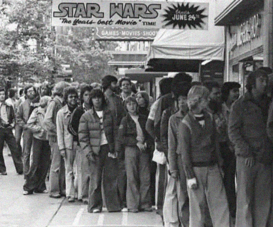 1. Waiting In Line to See Star Wars, 1977 1. Waiting In Line to See Star Wars, 1977, 2. January 19th 1977, The One and Only Day it Snowed in Miami, 3. Disco Sally, a 78-Year-Old Studio 54 Regular, Becomes a Symbol of the Era in 1978, 4. A Businessman Lights a Cigarette Inside a New York City Phone Booth in 1980, 5. Two Women Sit Casually on a Fire Escape in Harlem, NYC, in 1978, 6. Harrison Ford Appears as Colonel G. Lucas in Apocalypse Now, 1979, 7. In 1978, a Toddler Poses Next to the Family's New Color TV Like It's a Family Member, 8. Salesmen Sit on the Hoods of New Cars Waiting for Buyers at a California Dealership in 1979, 9. Kids Jump From a Fire Escape Onto Mattresses in NYC's Lower East Side, 1979, 10. Comic-Con San Diego in 1980 Captures the Wild Beginnings of Pop Culture Fandom, 11. The World's Largest Disco Draws Crowds to Buffalo in 1978, 12. Young Roller Skater in Red Moves Through Midtown Manhattan, 1979, 13. In 1978, Disco Dancing Lessons Spread to Suburbs Like Beaverton, Oregon, 14. An Apple II Computer and a Young Steve Jobs Revolutionize Tech in 1977, 15. A Woman Leans in to Kiss a Windsor Guard in a Whimsical Moment, 1980, 16. Two Guys Play Atari in Their Living Room in 1978, Defining Home Entertainment, 17. National Space Invaders Championship in 1980 Showcases a New Era of Gamers, 18. A Local News Crew in Texas Interviews Parents After Taking Kids to See Alien, 1979, 19. Young Woman in a "Consenting Adult" Shirt Enjoys the Rolling Stones in 1978, 20. In 1979, Reflections on the Dance Floor Captured the Disco Craze From Above, 21. A Canadian Gas Station Refuses to Fuel Soviet Ladas to Protest the Invasion of Afghanistan, 1980, 22. Subway Riders Carry Lawn Chairs for a Beach Day in NYC, Summer 1978, 23. High School Seniors Pose Before Heading on a Ski Trip in 1980, 24. Young Girl Embraces Teddy Boy Fashion and Rock 'n' Roll Dancing, 1979, 25. In 1980, Bronx Teens Turn the Streets Into a Stage With BMX Tricks, 26. Olivia Newton-John and John Travolta Redefine Teen Style on the Set of Grease, 1978, 27. KISS Fans in Buffalo, NY, Fully Embrace Glam Rock Culture, 1978, 28. New UK Prime Minister Margaret Thatcher Celebrates Her Election Victory, 1979, 29. The Sony Walkman Hits the Market With a Bold Ad Declaring "There's a Revolution in the Streets", 1980, 30. A Young Man Spins the Top Hits of 1978 on AM Radio Studio, 31. Four New Jersey Teens Check Under the Hood of a Car With a Backwards Design, 1979, 32. Elvis Presley's Final Performance in 1977 Leaves Fans With an Iconic Farewell, 33. Protesters Flood the Capitol in March 1980 to Oppose Military Draft Registration, 34. Staten Island Families Resort to Kerosene Lamps During the 1977 Blackout
