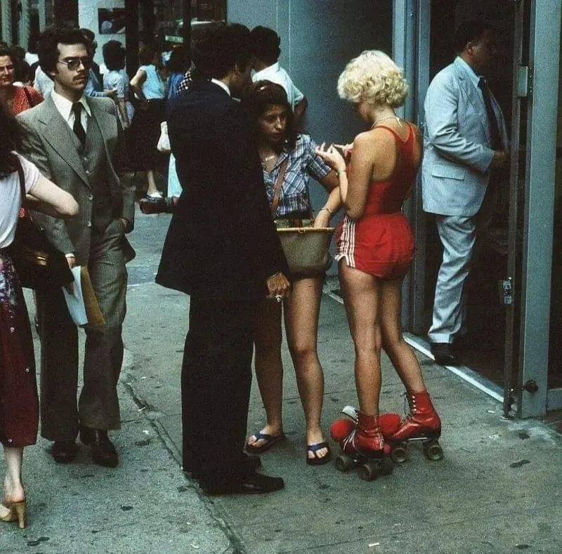 12. Young Roller Skater in Red Moves Through Midtown Manhattan, 1979 1. Waiting In Line to See Star Wars, 1977, 2. January 19th 1977, The One and Only Day it Snowed in Miami, 3. Disco Sally, a 78-Year-Old Studio 54 Regular, Becomes a Symbol of the Era in 1978, 4. A Businessman Lights a Cigarette Inside a New York City Phone Booth in 1980, 5. Two Women Sit Casually on a Fire Escape in Harlem, NYC, in 1978, 6. Harrison Ford Appears as Colonel G. Lucas in Apocalypse Now, 1979, 7. In 1978, a Toddler Poses Next to the Family's New Color TV Like It's a Family Member, 8. Salesmen Sit on the Hoods of New Cars Waiting for Buyers at a California Dealership in 1979, 9. Kids Jump From a Fire Escape Onto Mattresses in NYC's Lower East Side, 1979, 10. Comic-Con San Diego in 1980 Captures the Wild Beginnings of Pop Culture Fandom, 11. The World's Largest Disco Draws Crowds to Buffalo in 1978, 12. Young Roller Skater in Red Moves Through Midtown Manhattan, 1979, 13. In 1978, Disco Dancing Lessons Spread to Suburbs Like Beaverton, Oregon, 14. An Apple II Computer and a Young Steve Jobs Revolutionize Tech in 1977, 15. A Woman Leans in to Kiss a Windsor Guard in a Whimsical Moment, 1980, 16. Two Guys Play Atari in Their Living Room in 1978, Defining Home Entertainment, 17. National Space Invaders Championship in 1980 Showcases a New Era of Gamers, 18. A Local News Crew in Texas Interviews Parents After Taking Kids to See Alien, 1979, 19. Young Woman in a "Consenting Adult" Shirt Enjoys the Rolling Stones in 1978, 20. In 1979, Reflections on the Dance Floor Captured the Disco Craze From Above, 21. A Canadian Gas Station Refuses to Fuel Soviet Ladas to Protest the Invasion of Afghanistan, 1980, 22. Subway Riders Carry Lawn Chairs for a Beach Day in NYC, Summer 1978, 23. High School Seniors Pose Before Heading on a Ski Trip in 1980, 24. Young Girl Embraces Teddy Boy Fashion and Rock 'n' Roll Dancing, 1979, 25. In 1980, Bronx Teens Turn the Streets Into a Stage With BMX Tricks, 26. Olivia Newton-John and John Travolta Redefine Teen Style on the Set of Grease, 1978, 27. KISS Fans in Buffalo, NY, Fully Embrace Glam Rock Culture, 1978, 28. New UK Prime Minister Margaret Thatcher Celebrates Her Election Victory, 1979, 29. The Sony Walkman Hits the Market With a Bold Ad Declaring "There's a Revolution in the Streets", 1980, 30. A Young Man Spins the Top Hits of 1978 on AM Radio Studio, 31. Four New Jersey Teens Check Under the Hood of a Car With a Backwards Design, 1979, 32. Elvis Presley's Final Performance in 1977 Leaves Fans With an Iconic Farewell, 33. Protesters Flood the Capitol in March 1980 to Oppose Military Draft Registration, 34. Staten Island Families Resort to Kerosene Lamps During the 1977 Blackout