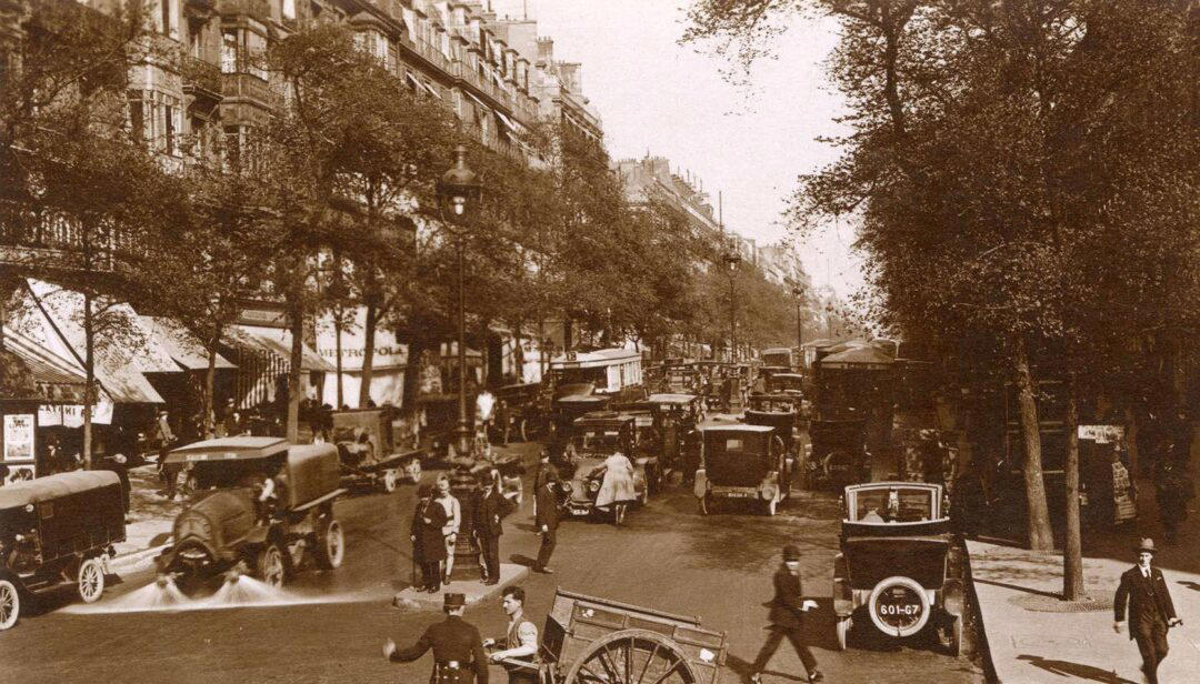9. ‘A Street Scene in Paris During the 1924 Olympics’ 1. A Woman Strolls Through Paris While Reading the Paper, 2. Two Kids Play With a Toy Car on a Cobblestone Street With the Moulin Rouge in the Distance, 3. ‘A Pair of Lovers in Paris, France’, 4. Visitors Stroll Beneath the Eiffel Tower During the 1925 Exposition Internationale des Arts Décoratifs, 5. Colorized Image of Parisians Browsing Flowers Near the Tour de l’Horloge on the Île de la Cité, One of the City’s Oldest Clocks, 6. ‘Soldiers at the Metro Station Auteuil on the Boulevard Excelmans in Paris, France, on May 1, 1920’, 7. Colorized Image of a Hot Air Balloon Pre-Take Off, May 1923, 8. Two Women Enjoy a Coffee on a Terrace, 1925, 9. ‘A Street Scene in Paris During the 1924 Olympics’, 10. A Woman Enjoys a Meal Aboard a Zeppelin Heading to Berlin, 1928, 11. A Couple Dances Along the Seine as People Look on, 12. Singer and Dancer Josephine Baker Pictured at a Cabaret, 1927, 13. Three Children Pause for a Snack With the Sacré-Coeur in the Distance, 14. ‘Ernest Hemingway in Paris, 1920s’, 15. ‘Citroen Automobile Designed by Sonia Delaunay in Paris, 1925’, 16. A Young Gloria Vanderbilt and Her Pet Dog Playing in Front of the Eiffel Tower, 1921, 17. ‘Backstage at the Moulin Rouge, Paris, 1924’, 18. ‘Early Color Photography in Paris, France, 1920’, 19. Josephine Baker Taking Her Pet Cheetah for a Walk in Paris, 1923
