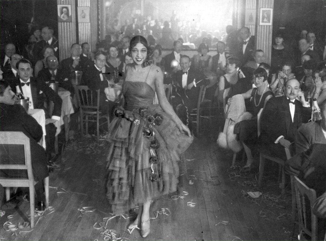 12. Singer and Dancer Josephine Baker Pictured at a Cabaret, 1927 1. A Woman Strolls Through Paris While Reading the Paper, 2. Two Kids Play With a Toy Car on a Cobblestone Street With the Moulin Rouge in the Distance, 3. ‘A Pair of Lovers in Paris, France’, 4. Visitors Stroll Beneath the Eiffel Tower During the 1925 Exposition Internationale des Arts Décoratifs, 5. Colorized Image of Parisians Browsing Flowers Near the Tour de l’Horloge on the Île de la Cité, One of the City’s Oldest Clocks, 6. ‘Soldiers at the Metro Station Auteuil on the Boulevard Excelmans in Paris, France, on May 1, 1920’, 7. Colorized Image of a Hot Air Balloon Pre-Take Off, May 1923, 8. Two Women Enjoy a Coffee on a Terrace, 1925, 9. ‘A Street Scene in Paris During the 1924 Olympics’, 10. A Woman Enjoys a Meal Aboard a Zeppelin Heading to Berlin, 1928, 11. A Couple Dances Along the Seine as People Look on, 12. Singer and Dancer Josephine Baker Pictured at a Cabaret, 1927, 13. Three Children Pause for a Snack With the Sacré-Coeur in the Distance, 14. ‘Ernest Hemingway in Paris, 1920s’, 15. ‘Citroen Automobile Designed by Sonia Delaunay in Paris, 1925’, 16. A Young Gloria Vanderbilt and Her Pet Dog Playing in Front of the Eiffel Tower, 1921, 17. ‘Backstage at the Moulin Rouge, Paris, 1924’, 18. ‘Early Color Photography in Paris, France, 1920’, 19. Josephine Baker Taking Her Pet Cheetah for a Walk in Paris, 1923