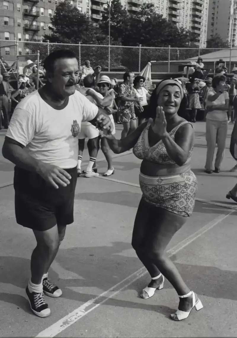 21. Dancing in the Streets of Brooklyn During A Joyful Block Party Moment in 1976 1. Queen Was on Fire in 1976, Even if the Hairstyles Were Questionable, 2. The Hudson River Lit Up with Boats and Patriotism on the 4th of July, 1976, 3. Barefoot and Beaming, Locals Paraded with Pride Through Pickering Beach in 1976, 4. A Helpful Hand at Kmart's Camera Counter as Film Photography Ruled 1976, 5. A Snapshot of LA Youth in the Summer of '76, 6. Festive Fries and Holiday Cheer at McDonald's in the Heart of the Seventies, 7. Marching to the Beat of Freedom During the 1976 Bicentennial Celebration, 8. A Fall Night on Broadway and 44th in 1976 Manhattan, 9. Candlelit Conversations and Cozy Vibes at a 1976 House Party, 10. This Toddler Had Style to Spare in 1976, 11. Lazy Beach Days and Summer Love in South Shields, 1976, 12. Packed Nights and Rock 'n' Roll Vibes Inside Max's Kansas City, NYC, 1976, 13. Americans Gather Around the Bicentennial "Freedom Train" Carrying Priceless Pieces of History, 14. Teenage Love Caught on Camera in a Quiet New York Room, 1976, 15. Chaos and Cheers at the Battle Royal in L.A.'s Olympic Auditorium, 16. Jodie Foster Stuns at Just 14 in the Gritty Classic Taxi Driver, 1976, 17. The Power of Christ Compels You at Detroit’s Infamous Exorcist Lounge, 1976, 18. Arcade Dreams and Mall Magic Collide at Old Chicago in 1976, 19. School Vaccinations in 1976 Highland Park, 20. Dancing in the Streets of Brooklyn During A Joyful Block Party Moment in 1976, 21. Serving Up Street Flavor Outside the Met on a Summer Day in 1976, 22. A Group of Kids Waits Patiently for the Subway in a Gritty 1976 New York City, 23. Neighborhood Kids Gear Up for Halloween With Their Spookiest Masks in 1976, 24. President Jimmy Carter Casually Hops a Fence at LaGuardia Airport With an Aide, 1976, 25. Dining Above the Clouds at Windows on the World, 1976, 26. David Bowie in 1976, Redefining Cool with Every Glance, 27. AC/DC Rocking Their Way to Global Fame in 1976, 28. A Young Woman Hitchhiking Through Florida's Sun-Soaked Highways in 1976, 29. A Group of Young Concertgoers Soaking Up the Vibes in Ohio, 30. A Surprising Snapshot of Hollywood Charm, 31. When Superheroes Took the Plunge at SeaWorld's Wild 1976 Show, 32. Charlie's Angels Redefined Cool and Confidence in 1976, 33. Kiss Turns Heads While Strutting Through NYC in Full Costume, 1976