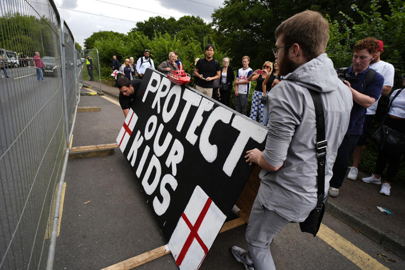 Pictured: Anti-migrant protesters gather outside Britannia Hotel in Canary Wharf, Pictured: Anti-migrant protesters gather outside Bell Hotel in Epping, Protesters and counter-demonstrators gather in Epping, Pictured: Stand Up To Racism crowd grows ahead of Epping protest, Canary Wharf locals protest use of Britannia hotel for migrants, Two men charged with public order offence after Diss hotel protest, Pictured: Police gather in Epping ahead of migrant hotel protests, Poll reveals British view on small boat crossings, Residents feel 'trapped' as harassment fears grow around migrant hotel protests, Nigel Farage apologises after false Epping protest claim, Elite police division monitoring social media to prevent Epping unrest, What caused the Epping anti-migration protests?, Essex police announces plan for Epping protests, Protests organised by members of Neo-Nazi groups, Police announce new protest restrictions to tackle unrest, Asylum seekers afraid to leave hotel amid protests