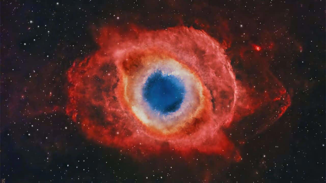 A Helix Nebula Deep Field: The Helix Nebula, a bright planetary nebula 650 light-years away, resembles a cosmic eye. Its glowing gases and complex structure mark a dying star’s final breath in vivid detail. (Image: NASA)