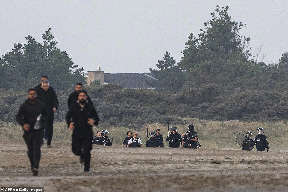 French police stand watching as boat load of migrants set off for UK
