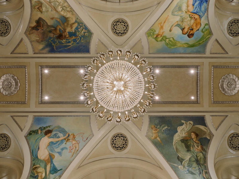 The ceiling featured murals by American artist Edward Emerson Simmons, which were restored from the original Waldorf Astoria location.