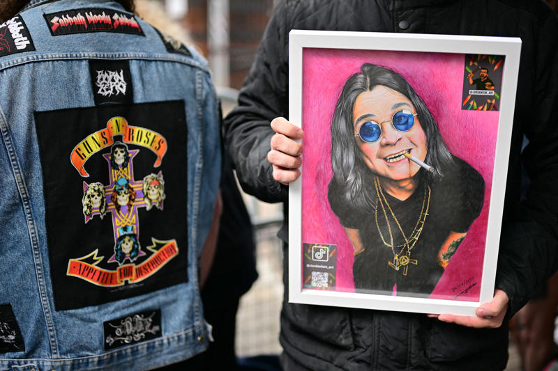Ozzy Osbourne's funeral - key points, How to watch the Black Sabbath bench livestream, PICTURES: Fans line the streets of Birmingham ahead of Ozzy funeral procession, VIDEO: Ozzy Osbourne reveals the song that changed his life, Yungblud's moving tribute to Ozzy, Thousands of fans travel to Birmingham... and the pints are already flowing, Mayor calls Ozzy Osbourne 'a son of Birmingham', Ozzy fan renames his pet 'Doggy Osbourne' for the day, 'Ozzy Osbourne was completely himself... money didn't change him', Ozzy Osbourne flung open hell’s musical gates – and changed the world, Couple Karen and Steve Brookhouse: 'There will never be another Ozzy', Hundreds of people are already gathered at the barriers, Ozzy Osbourne wanted his funeral to be ‘celebration, not a mope-fest’, Graffiti artist Mr Murals helps touch up murals before the funeral procession, What Ozzy's fellow artists said in tributes after his death, Senior reporter Holly Evans is in Birmingham ahead of the funeral procession, Fans prepare to say final goodbye to the Prince of Darkness, Who are Bostin' Brass Band, the group playing alongside Ozzy's hearse?, Flowers, tributes and a brass band outside the Black Sabbath bench, Birmingham mayor describes Ozzy Osbourne as 'son of Birmingham, In pictures: Fans arrive and floral tributes laid ahead of funeral