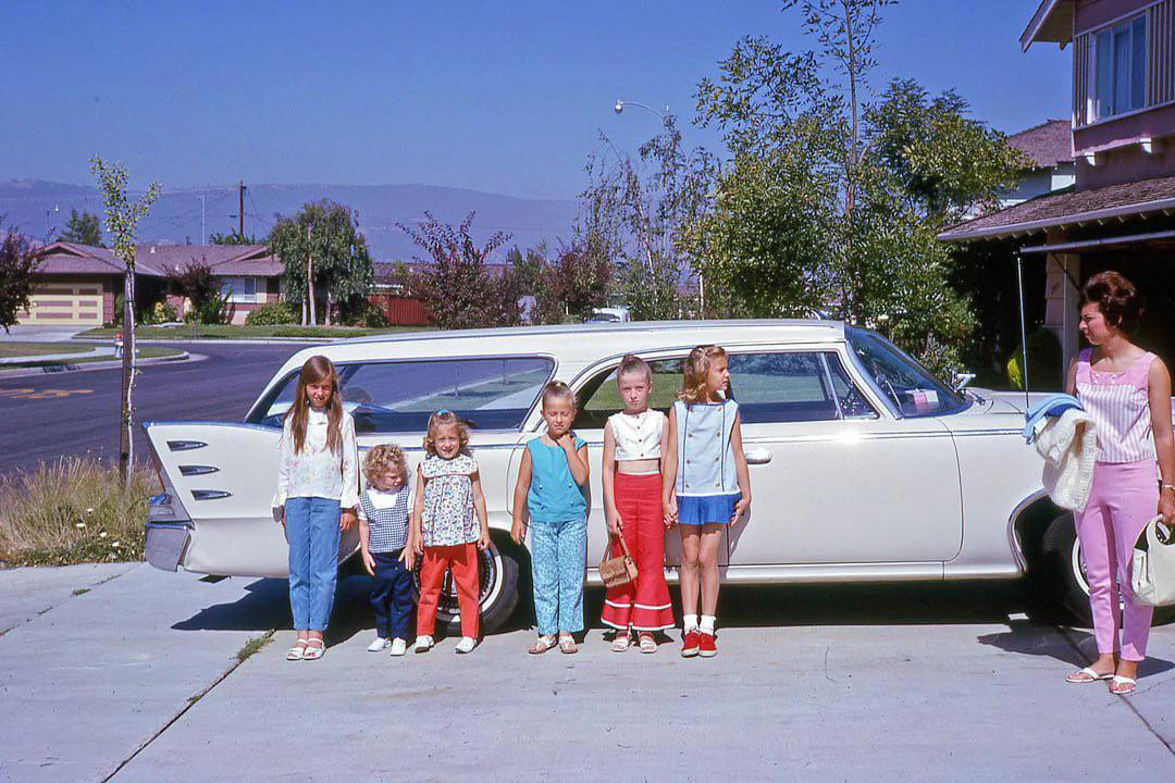 14. Kids Posing by Their Family Vehicle (1966) 1. Boys Setting Up Their Train Model (1946), 2. Dangerous Curves (1949), 3. Before Prom (1967), 4. Going for a Ride in the Convertible (1957), 5. Enjoying a Day at the Public Pool (1960s), 6. Mespelbrunn Castle in Bavaria, Germany, 7. Diving Contest in Palm Beach, Florida (1959), 8. Waiting on a Prom Date (1950s), 9. A Husband’s Portrait of His Wife (1954), 10. Times Square (1959), 11. Little Girl Fishing on the North Shore of Oahu (1960), 12. Couple on Vacation in Florida (1950s), 13. A Baker and His Bread (1950s), 14. Kids Posing by Their Family Vehicle (1966), 15. Brothers Playing in the Snow (1963), 16. Dogs Like Rides Too (1962), 17. Orphan Children from Mooseheart, Illinois (1948), 18. Stopping at Texaco on a Road Trip (1958), 19. Toddler Walking Around in Flowers (1954), 20. Boys on a Camping Trip (1965), 21. Saying Goodbye to Grandma (1950), 22. Picnic in France (1969), 23. A Night at the Bar (1950s), 24. Typical Teen Party (1978)