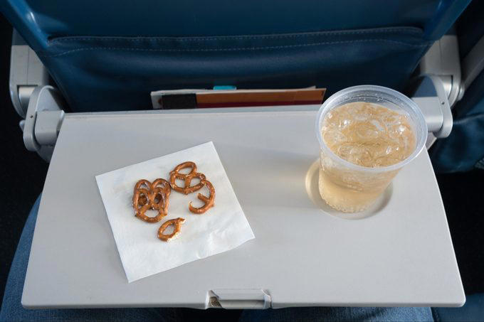 Eat the airplane food, Wear shorts, Drink the plane water, Use the blankets, pillows and mattresses, Go barefoot, Ignore the safety briefing, Sit in the last row, Have more than one alcoholic drink, Book the very last flight of the day, Wear contact lenses the whole flight, Keep the seat reclined during meal service, Put valuables in the seat pocket, Stand in the aisle right after landing, Eat right off the tray table, Assume your checked bag will arrive with you, About the experts, Why trust us, Sources: