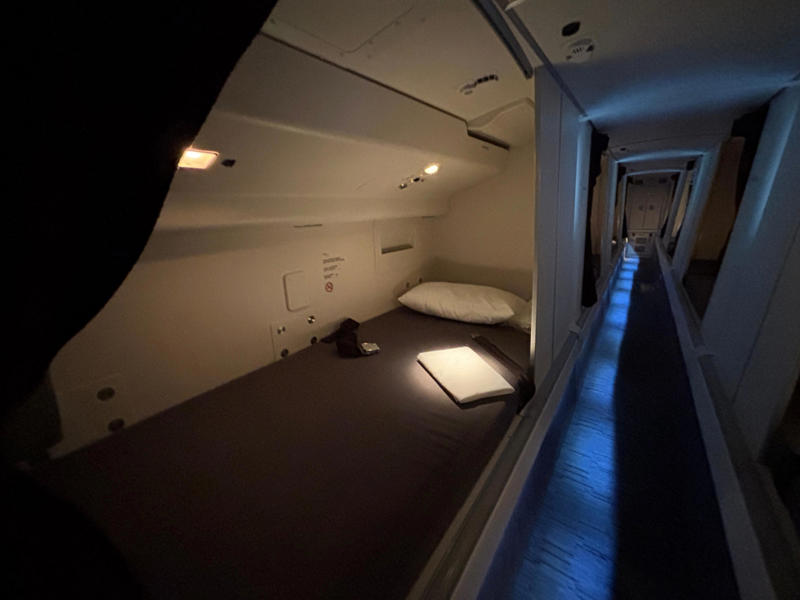 See inside the hidden area where Qatar Airways flight attendants sleep on long-haul Boeing 777 flights The door opens to reveal a steep and narrow staircase., It was slightly eerie looking down the dim and lengthy corridor., However, the beds themselves didn't look too uncomfortable., Each bed had pockets for storage, a coat hook, and a mirror.
