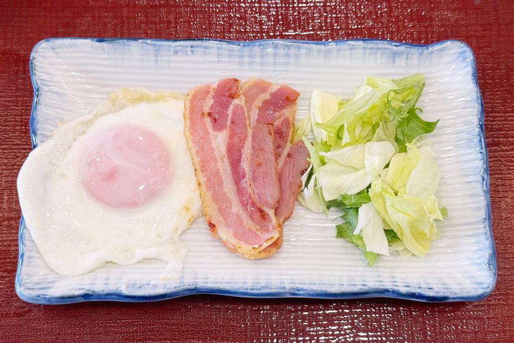 実は「なか卯」って安い？価格据え置きでお得感が爆増中！, なか卯の新メニューはうどんモーニング！しかもワンコイン以下！, 最安290円を維持！なか卯の朝限定メニュー一覧, なか卯のうどん朝食、冷やしはいからうどん ベーコンエッグ 450円, さっぱりおいしい、夏の朝にもぴったりの冷たいうどん, 卵へのこだわりを堪能できる目玉焼き, うれしい心配り。つけ合わせのしば漬けにも注目, なか卯の独自進化が朝の選択肢を豊かにする理由, わがままを叶えてくれる、なか卯のうどん朝食
