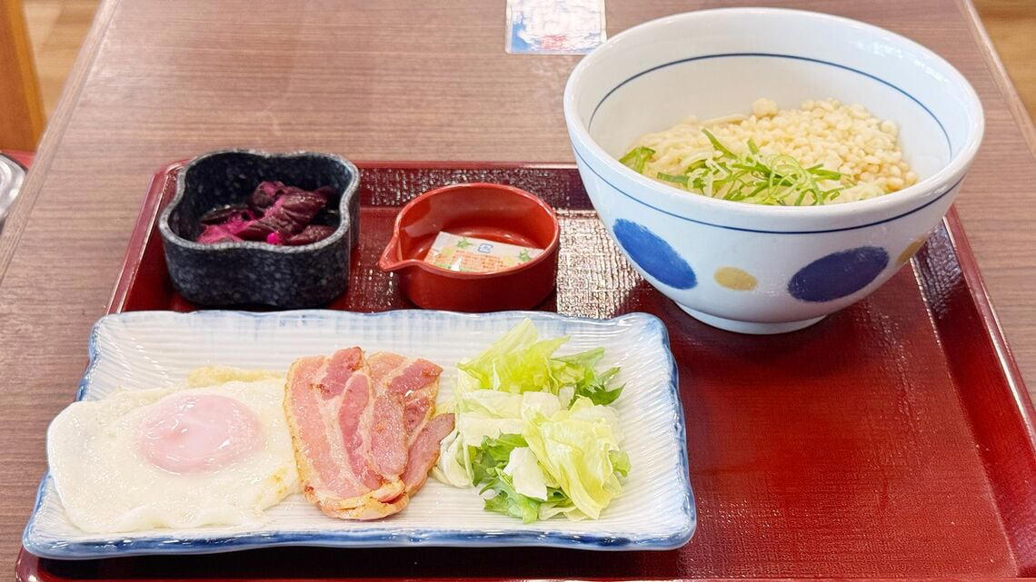 実は「なか卯」って安い？価格据え置きでお得感が爆増中！, なか卯の新メニューはうどんモーニング！しかもワンコイン以下！, 最安290円を維持！なか卯の朝限定メニュー一覧, なか卯のうどん朝食、冷やしはいからうどん ベーコンエッグ 450円, さっぱりおいしい、夏の朝にもぴったりの冷たいうどん, 卵へのこだわりを堪能できる目玉焼き, うれしい心配り。つけ合わせのしば漬けにも注目, なか卯の独自進化が朝の選択肢を豊かにする理由, わがままを叶えてくれる、なか卯のうどん朝食