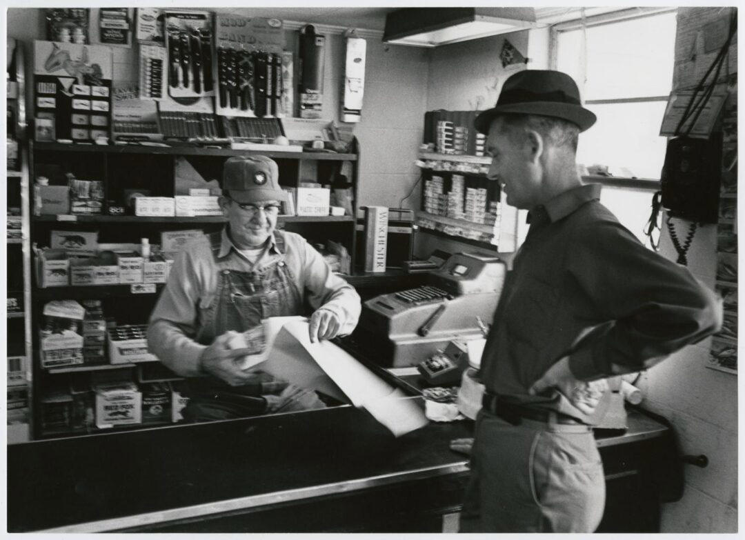 1. Country Store in Oklahoma (1940), 2. Uncle Newt’s Store in Hardin, Tennessee (1945), 3. Woman Looking in a ‘Men Only’ Machine at the Vermont Country Store (1954), 4. Checking Out at a Lynchburg, Tennessee, Store (1972), 5. Double Decker Store in Prospect Hill, North Carolina (1940), 6. McLeary Store, Outside of Salem, Oregon (1959), 7. W.B. Queen, a Fiddler, Playing in a Country Store in Tellico Plains, Tennessee (1941), 8. Soldiers From Fort Benning Playing Pinball in an Alabama Country Store (1941), 9. Putting Ice in the Soft Drink Refrigerator at a Store in Arkansas (1938), 10. General Store in Bigheart, Oklahoma (1908), 11. Grinding Coffee at the General Store in Castolon, Texas (1939), 12. Poolroom at the General Store in Granville County, North Carolina (1940), 13. Manning the Counter (1973), 14. General Store in Moundville, Alabama (1936), 15. Dowd’s Store in Fibre, Michigan (1952), 16. Farm Boy at a General Store Pop Stand in Iowa (1939), 17. Country Store Off a Dirt Road in North Carolina (1939)