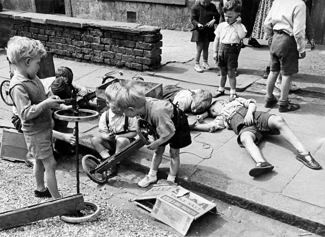 1. Kids Playing in the Streets of Brooklyn, New York, 1950, 2. Neighborhood Baseball on a Quiet Suburban Street, 1958, 3. Neighborhood Bike Gang, 1970s, 4. ‘Kids Playing Outside in Dumont, New Jersey, 1977’, 5. Homemade Playground in an Alley, 1950, 6. Someone Give This Kid a Stuntman Career, 1980s, 7. Children Playing on Peace Street in London’s East End, 1950s, 8. Just Some Friends Turning an Old Barrel Into the Perfect Playground, 9. This Jungle Gym Would Certainly Not Fly Today, 1942, 10. Scaling Brick Walls in Abandoned Building Was Just Part of the Fun, 11. Skater Boys Unite! New Jersey, Late ’80s, 12. A Police Officer Plays Tag With Local Kids in Harlem, New York, 1978, 13. Neighborhood War Games With Makeshift Weapons, 1960s, 14. Cutest Repair Shop I Ever Did See, 15. ‘Neighborhood Kids Playing War in Washington D.C., 1942’, 16. Just Some Buddies Hanging Out in Sydney, Australia, 1989, 17. Summertime Fun With a Shopping Cart, Harlem, New York, 1980s, 18. There’s a New Sheriff in Town and He Ain’t Playing Around, 19. ‘Kids Playing Street Hockey, 1976’