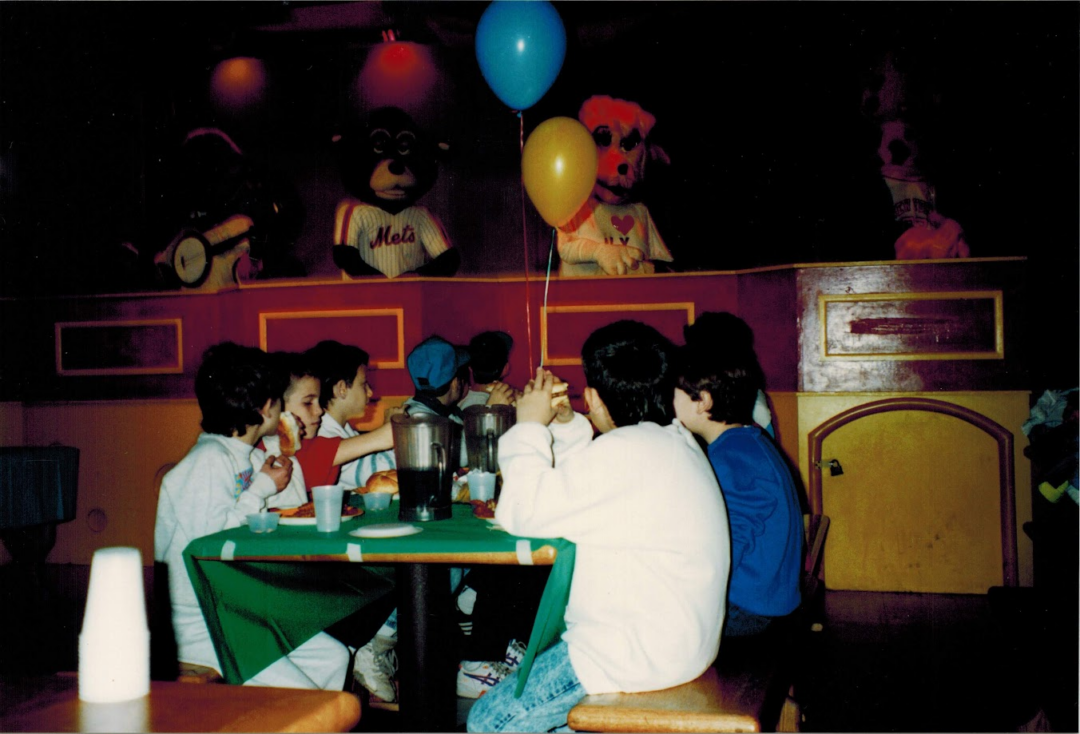 1. Core Memories in the Making, 2. Fresh Pizza Delivered By Chuck Himself? Talk About Birthday Goals, 2. ‘Looking Tough on My 6th Birthday at Chuck E. Cheese in 1996’, 4. Admittedly, Chuck Looked a Bit Creepy at Times, 5. Bet He Remembers the Rage to This Day: ‘The Exact Moment a Random Kid Blew Out My Candles at Chuck E. Cheese in 1991’, 6. A Crown Fit for a [Small] Queen, 7. ‘My Chuck E. Cheese Birthday Party, 1986’, 8. Enjoying Some Pizza While Watching the Animatronic Band, 9. ‘Birthday Party at the Very First Chuck E. Cheese in the Old Town and Country Village Shopping Center’, 10. ‘Fun Birthday Party at Chuck E. Cheese, Late ’80s’, 11. Grown Up Parties Welcome, Too!, 12. No Birthday Was Complete Before All the Gifts Were Opened, 13. You Don’t Say: ‘Me in 1987 With a Creepy-Looking Chuck E Cheese’, 14. ‘At Chuck E. Cheese Proudly Showing Off My Coins, 1993’, 15. ‘Me at Chuck E. Cheese on My 5th Birthday, July 1982’