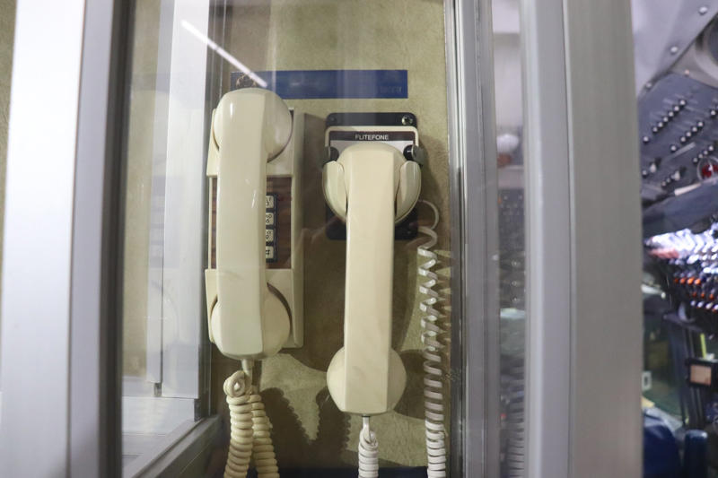 Two phones were located behind the flight deck. Two phones were located behind the flight deck., An equipment storage space featured a first aid kit and firearms., Next, I walked by the plane's communication facility., Meals were prepared in the galley., The presidential stateroom was located down a long hallway., The president's spacious quarters featured a desk, couch, television, and private bathroom., The stateroom came with two phones, each with different purposes., Behind the presidential stateroom, a conference room provided more meeting space.