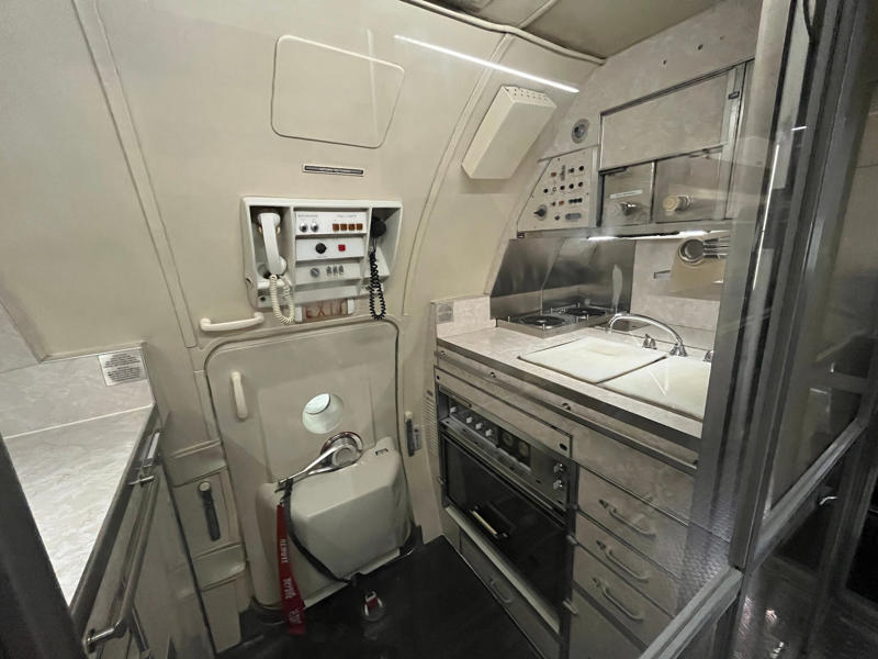 Meals were prepared in the galley. Two phones were located behind the flight deck., An equipment storage space featured a first aid kit and firearms., Next, I walked by the plane's communication facility., Meals were prepared in the galley., The presidential stateroom was located down a long hallway., The president's spacious quarters featured a desk, couch, television, and private bathroom., The stateroom came with two phones, each with different purposes., Behind the presidential stateroom, a conference room provided more meeting space.