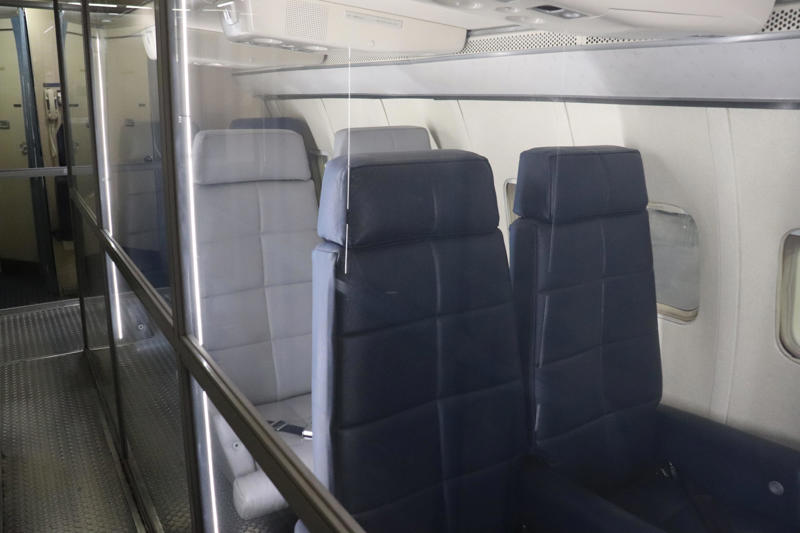 These four seats toward the back of the plane were removed to make room for Kennedy's coffin on the flight from Dallas back to Washington, DC, in 1963. Two phones were located behind the flight deck., An equipment storage space featured a first aid kit and firearms., Next, I walked by the plane's communication facility., Meals were prepared in the galley., The presidential stateroom was located down a long hallway., The president's spacious quarters featured a desk, couch, television, and private bathroom., The stateroom came with two phones, each with different purposes., Behind the presidential stateroom, a conference room provided more meeting space.