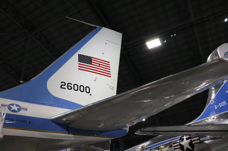 My tour ended at the back of the plane with a view of its call sign on the tail and an American flag. Two phones were located behind the flight deck., An equipment storage space featured a first aid kit and firearms., Next, I walked by the plane's communication facility., Meals were prepared in the galley., The presidential stateroom was located down a long hallway., The president's spacious quarters featured a desk, couch, television, and private bathroom., The stateroom came with two phones, each with different purposes., Behind the presidential stateroom, a conference room provided more meeting space.