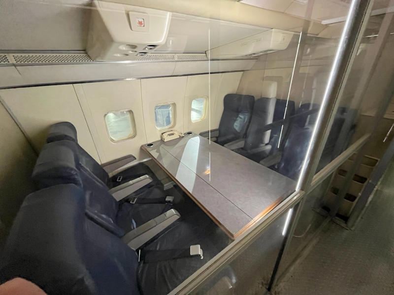 Air Force security personnel operated out of this area at the back of the aircraft to secure the plane while it was on the ground. Two phones were located behind the flight deck., An equipment storage space featured a first aid kit and firearms., Next, I walked by the plane's communication facility., Meals were prepared in the galley., The presidential stateroom was located down a long hallway., The president's spacious quarters featured a desk, couch, television, and private bathroom., The stateroom came with two phones, each with different purposes., Behind the presidential stateroom, a conference room provided more meeting space.