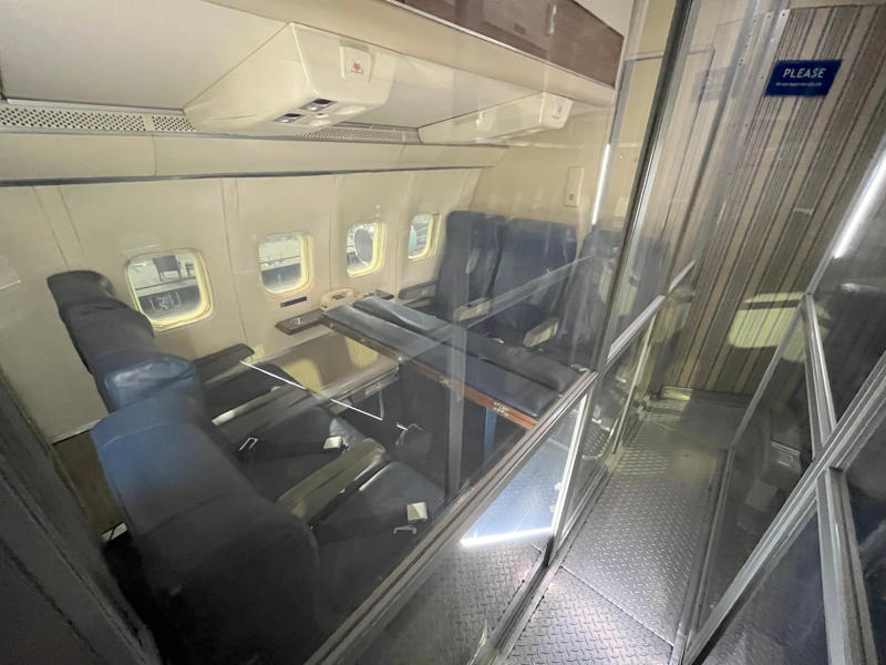 This seating area was used by presidential staff, members of the press, and Secret Service agents. Two phones were located behind the flight deck., An equipment storage space featured a first aid kit and firearms., Next, I walked by the plane's communication facility., Meals were prepared in the galley., The presidential stateroom was located down a long hallway., The president's spacious quarters featured a desk, couch, television, and private bathroom., The stateroom came with two phones, each with different purposes., Behind the presidential stateroom, a conference room provided more meeting space.