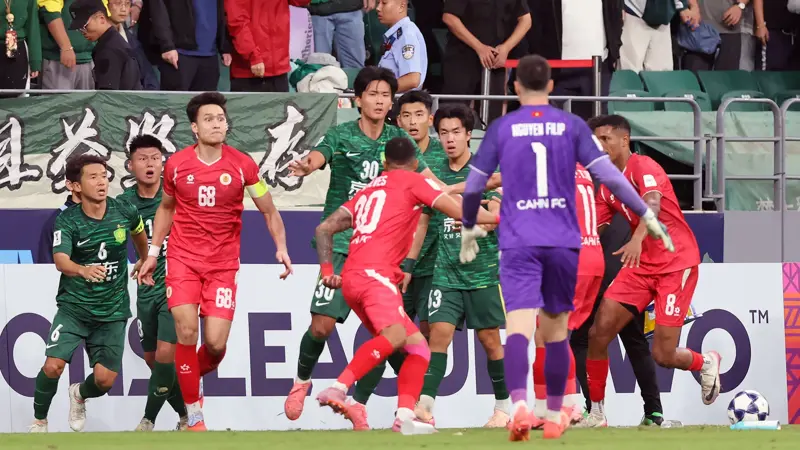 中国とベトナムのサッカー選手が乱闘。, AFCチャンピオンズリーグの試合中に混乱が発生。, 北京国安対ベトナム・ハノイ戦の終盤、乱闘が勃発した。, 両チームの選手が入り乱れての大乱闘。, 時間を無駄にしていた事から口論となり、さらには乱闘へと発展した。, 激しい殴打で状況は緊迫した。, 審判は落ち着きを取り戻そうと奮闘した。, 試合は6分以上中断された。, スタンドから観客がピッチにボトルを投げ入れて抗議した。, 看板の上に倒れる選手もいた。, 意外なことに、審判は誰も退場させなかった。, 緊迫したこの試合は2-2で終了した。